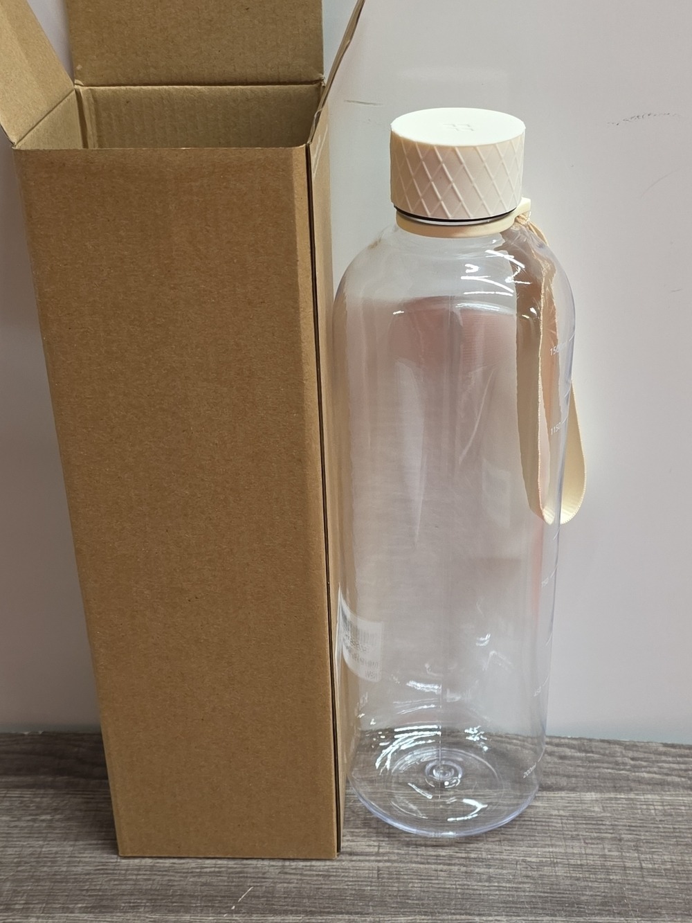 Clear Plastic Water Bottle with Beige Cap and Strap